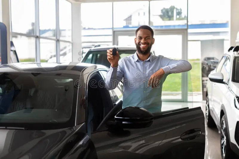 happy-black-man-holding-car-keys-standing-near-automobile-dealership-center-portrait-luxury-joyful-african-american-432087716